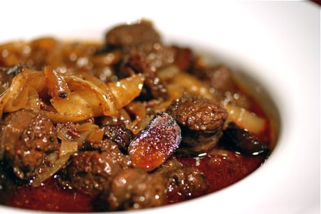 Bowl of chorizo and figs in sauce.