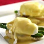 Eggs benedict with asparagus on a plate.