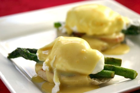 Eggs benedict with asparagus on a plate.