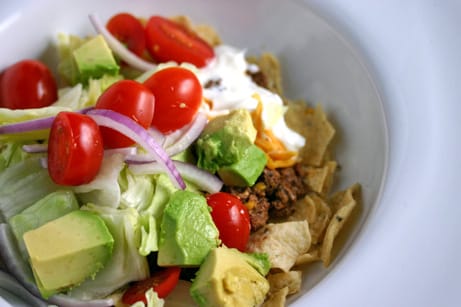 Taco salad with tortilla chips in a bowl.