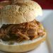 Pulled pork sandwich on a sesame seed bun.