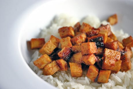 Bowl of baked tofu over rice.