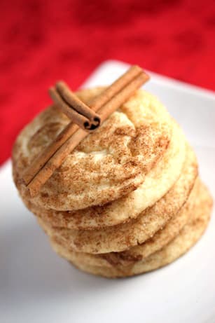 Stack of snickerdoodle cookies topped with cinnamon sticks.
