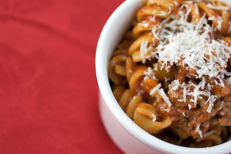 Overhead view of a bowl of pasta with beef and Parmesan.