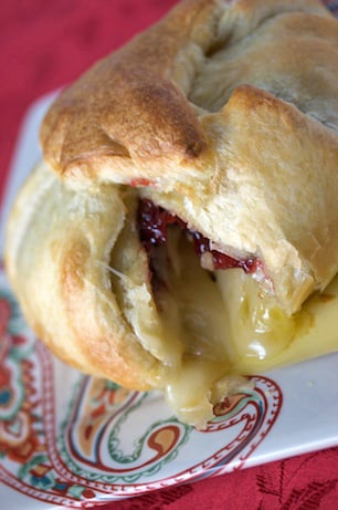 Overhead view of baked brie with a slice taken out.