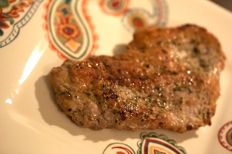 Cooked pork chop on a plate.