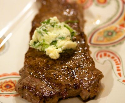Steak with compound butter on a plate.