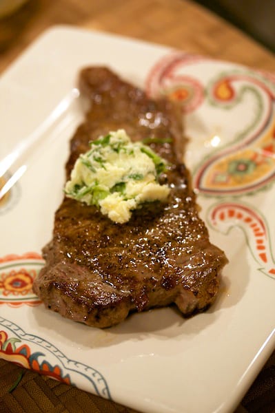 Steak with compound butter on a plate.