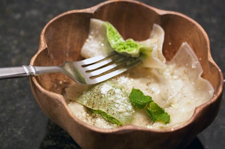 Ravioli filled with peas and parmesan in a bowl.