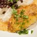 Plate of crusted chicken with beans and rice.