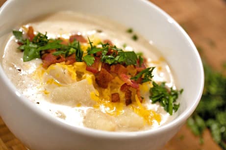 A bowl of baked potato soup with bacon.