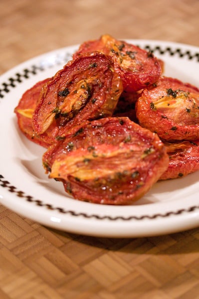 Pile of oven-roasted tomatoes on a plate.