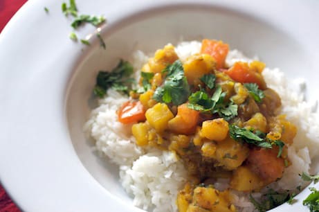 Bowl of curried potatoes over rice.