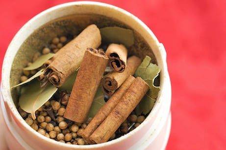 Whole spices in a spice grinder.