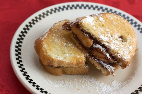 Grilled Nutella and banana sandwich with powdered sugar.