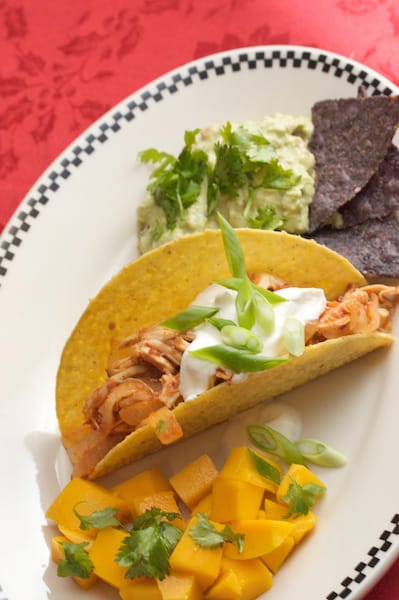 Chicken taco with guacamole and tortila chips.