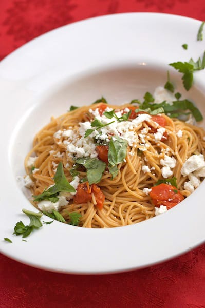Overhead view of a plate with spaghetti and goat cheese.