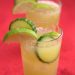 Two glasses of agua fresca with cucumber and lime garnishes.