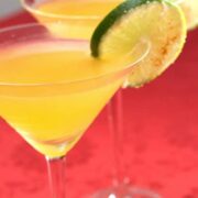 Two passion fruit chili margaritas with lime wheel garnish.
