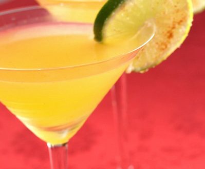 Two passion fruit chili margaritas with lime wheel garnish.