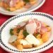 Cantaloupe and prosciutto on a plate with shaved Parmesan.