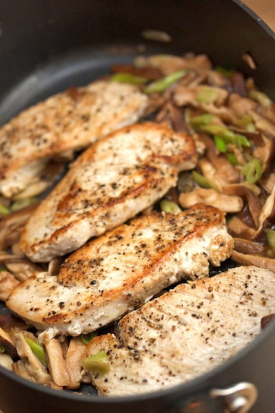 Turkey cutlets with shiitake mushrooms in a skillet.