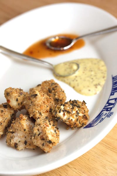 Chicken nuggets with dipping sauces on a plate.