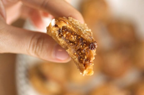 A hand holding a fig stuffed with walnuts.