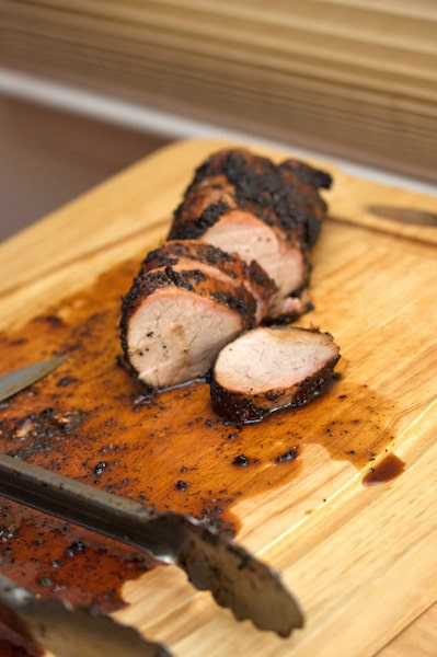 Sliced pork tenderloin on a cutting board.