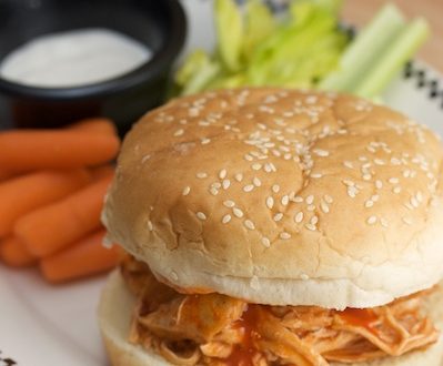 Buffalo chicken sandwich with carrots, celery, and blue cheese dip.