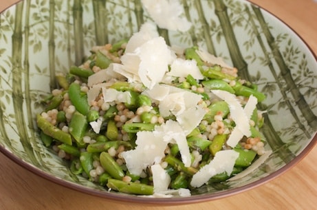 Bowl of Israeli couscous with asparagus and peas.