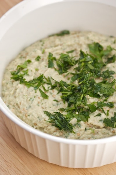 Bowl of babaghanoush topped with parsley.