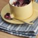 Semolina pudding with blueberry sauce in a cup with a small spoon.
