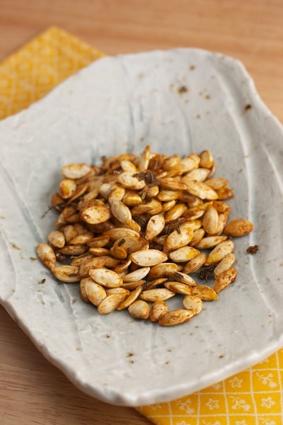 Roasted kabocha seeds on a plate.