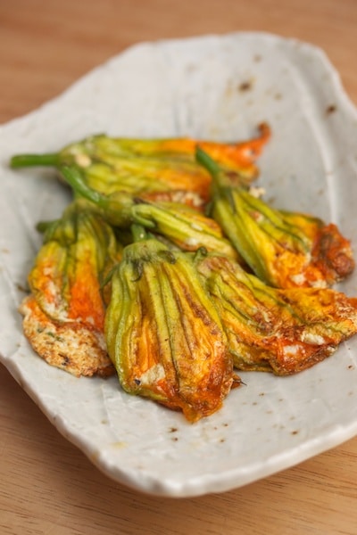 Ricotta stuffed zucchini blossoms on a plate.