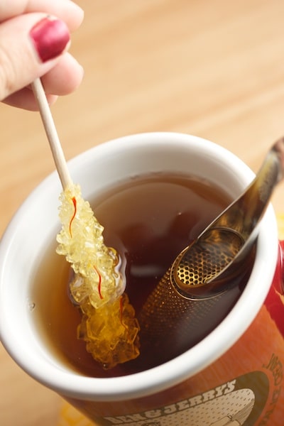 Saffron rock candy being stirred into a mug of tea.