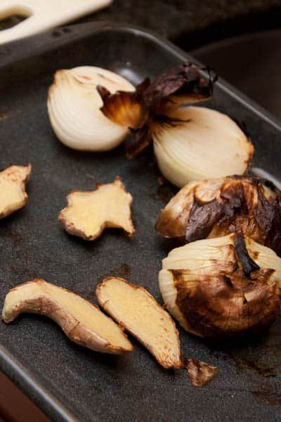 Broiler pan with charred onions and ginger.