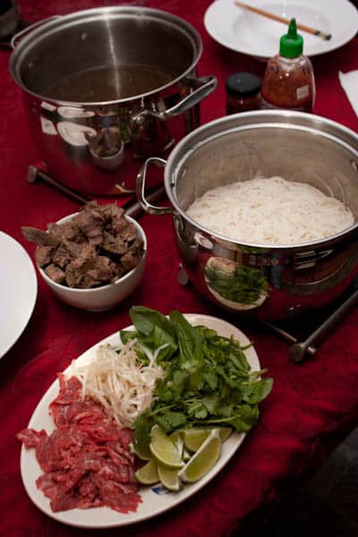 A table with pho ingredients ready for assembly.