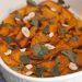 Casserole dish of marinated butternut squash with garlic and mint.