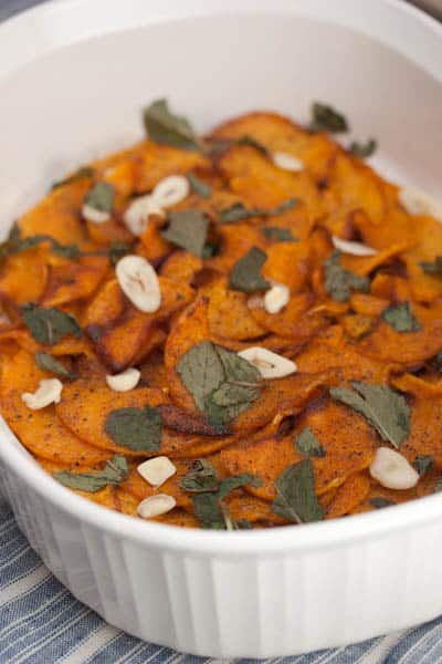 Casserole dish of marinated butternut squash with garlic and mint.