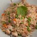 A bowl of pork fried rice and vegetables.