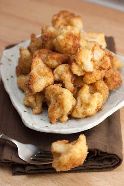 A plate of fried cauliflower with a fork.