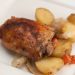 A plate of baked chicken with potatoes.