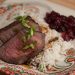 A plate of London broil with rice and cranberry sauce.