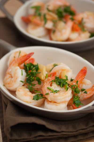 Shrimp in small serving dishes topped with parsley.