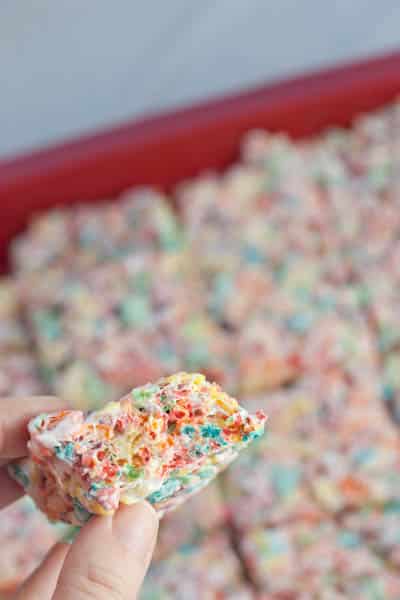 Rainbow krispy bars with one being held up to the camera.