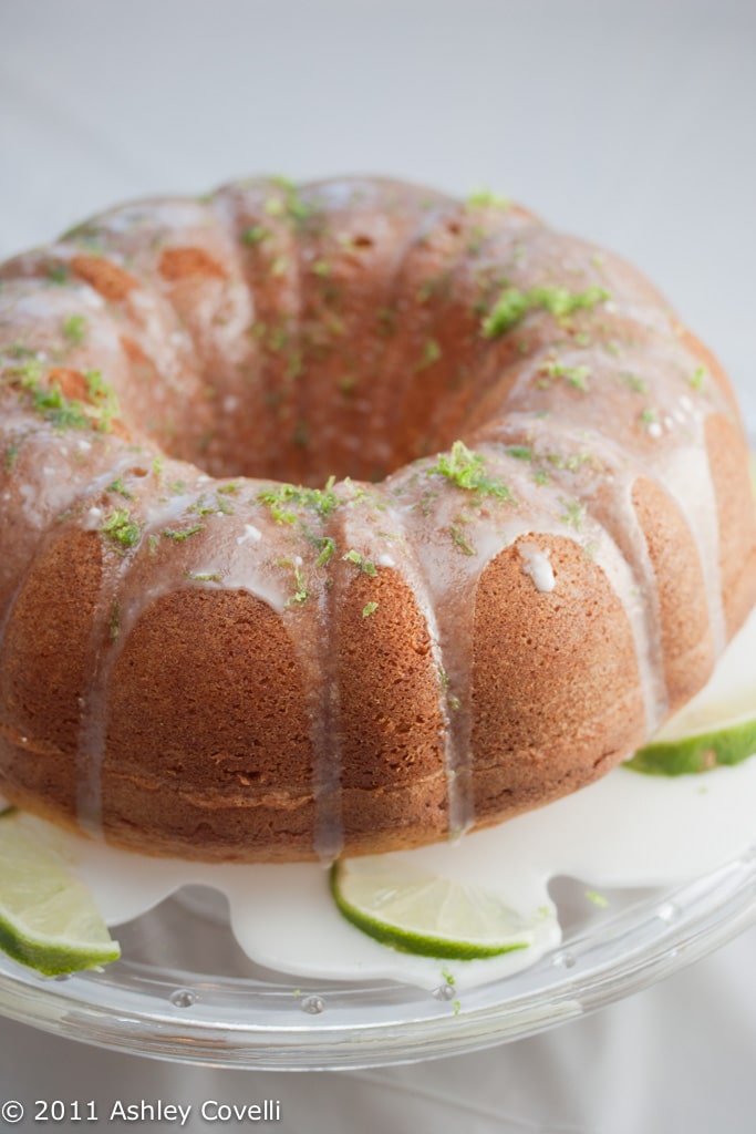 Margarita bundt cake on a cake stand with lime garnish.