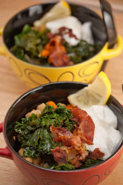 Bowls of garbanzo beans with greens, bacon, sour cream, and lemon.