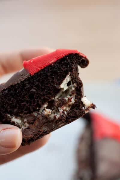 Cross section of a chocolate cupcake with red frosting.