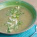 Bowl of celery and pear bisque with a spoon.